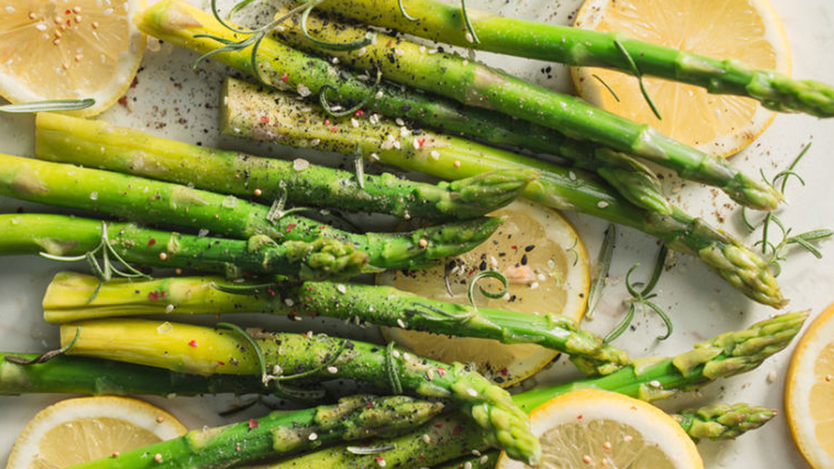 Cooked asparagus with sliced lemon.